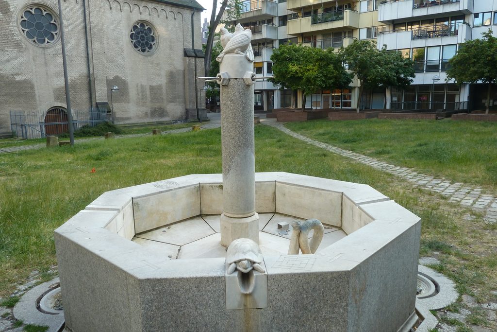 Tierbrunnen an Groß St. Martin nach der Sanierung mit Marmorpapageien auf dem Brunnenstock und Schildkröte am Beckenrand.
