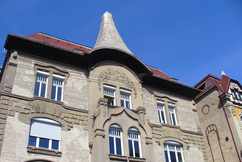 Steinerne Schildkröte neben einem langen verschlungenen Jugendstilornament an einem Stuttgarter Wohnhaus.