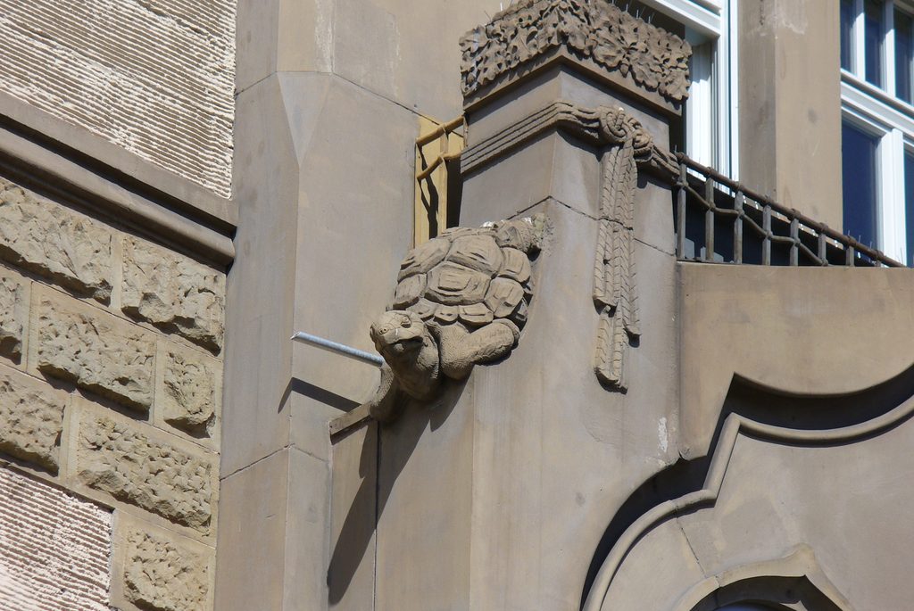 Eine plastische Schildkrötenfigur im Jugendstilstil an einer Hausfassade in Stuttgart.