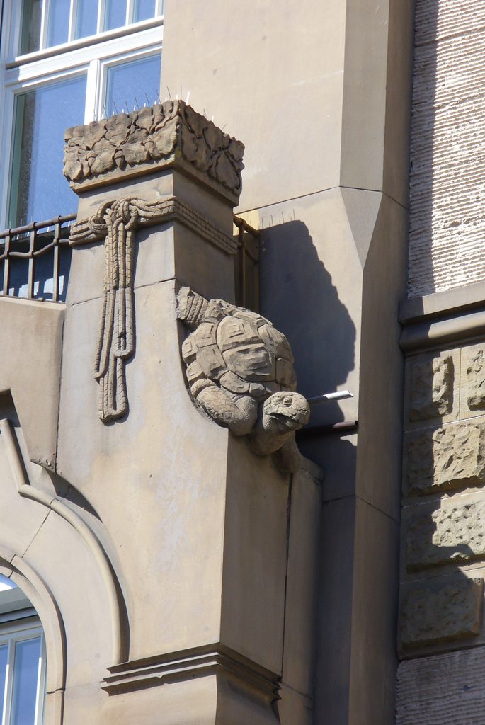 Nahaufnahme einer steinernen Landschildkröte an einer Jugendstilfassade in Stuttgart.